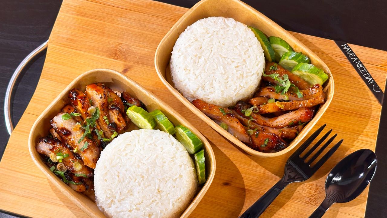 Two takeaway boxes of BBQ pork and rice